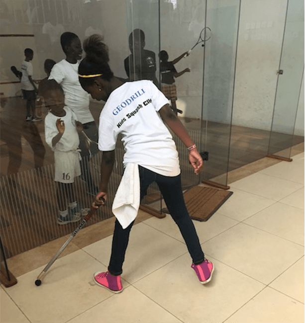 A squash novice trying her hands on the racquet and ball.